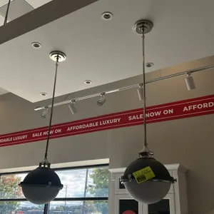 Ceiling pendant light fixtures. Features matte black upper metal dome shades, frosted white glass diffusers, and polished chrome-tone downrods, trim r