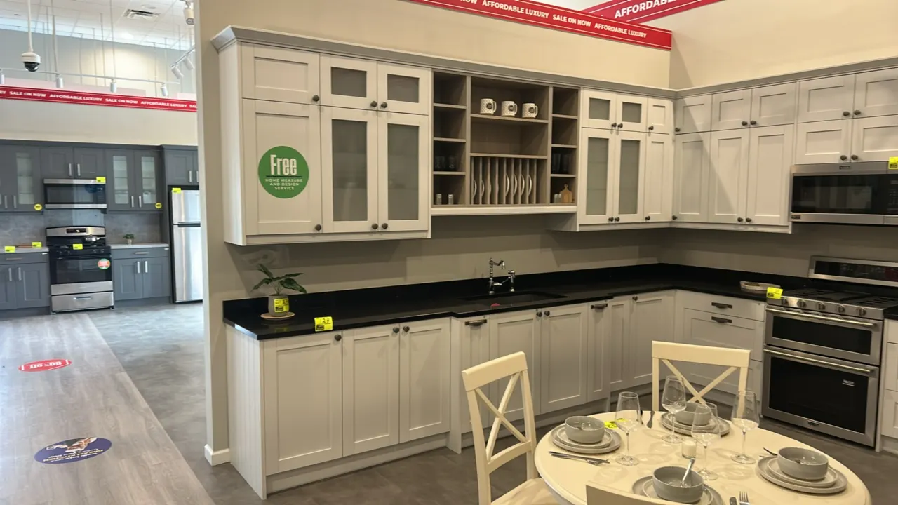 Infinity Plus laminate kitchen cabinet set. Features white shaker-style cabinetry, frosted glass doors, integrated plate rack, corner pantry, open she