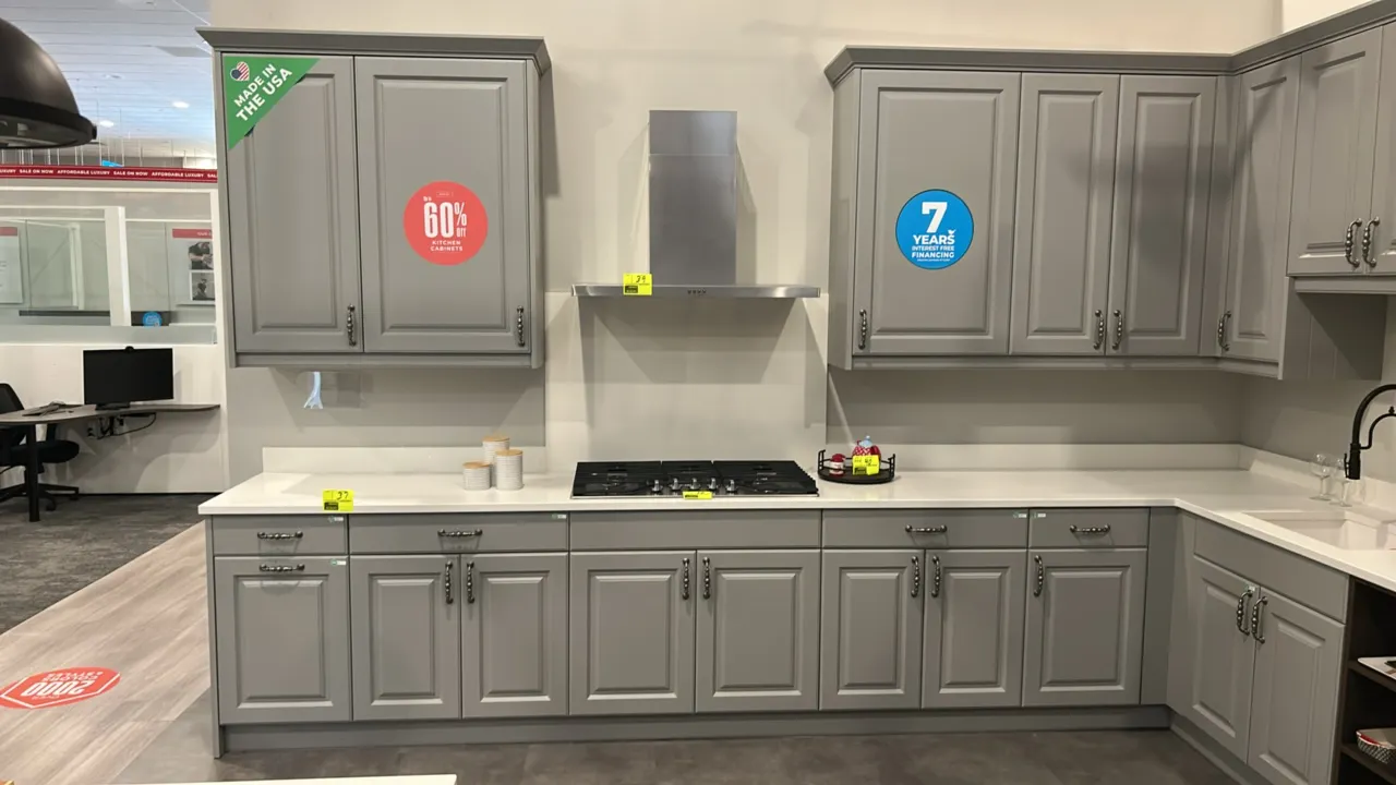 Infinity Plus laminate kitchen cabinet suite. Features gray raised-panel doors and drawers, upper and lower cabinetry, built-in upper wine rack, open