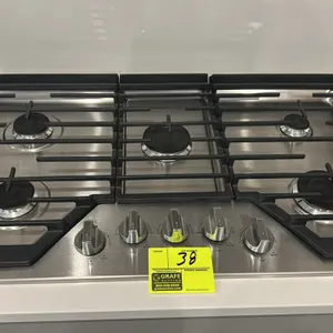 Whirlpool WCG55US6HS05 36" 5-burner gas cooktop. Features stainless steel construction, continuous cast iron grates, and front-mounted control knobs. 