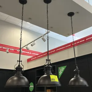 Bronze metal dome ceiling hanging pendant lights. Features industrial-style dome shades with dark bronze finish, frosted glass bottom diffusers, decor