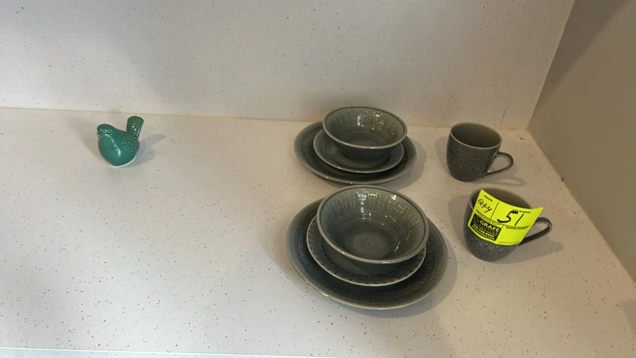 Assorted ceramic dinnerware and decorative figurine. Includes (2) dinner plates, (2) salad plates, (2) bowls, (2) mugs, and (1) glazed green ceramic b