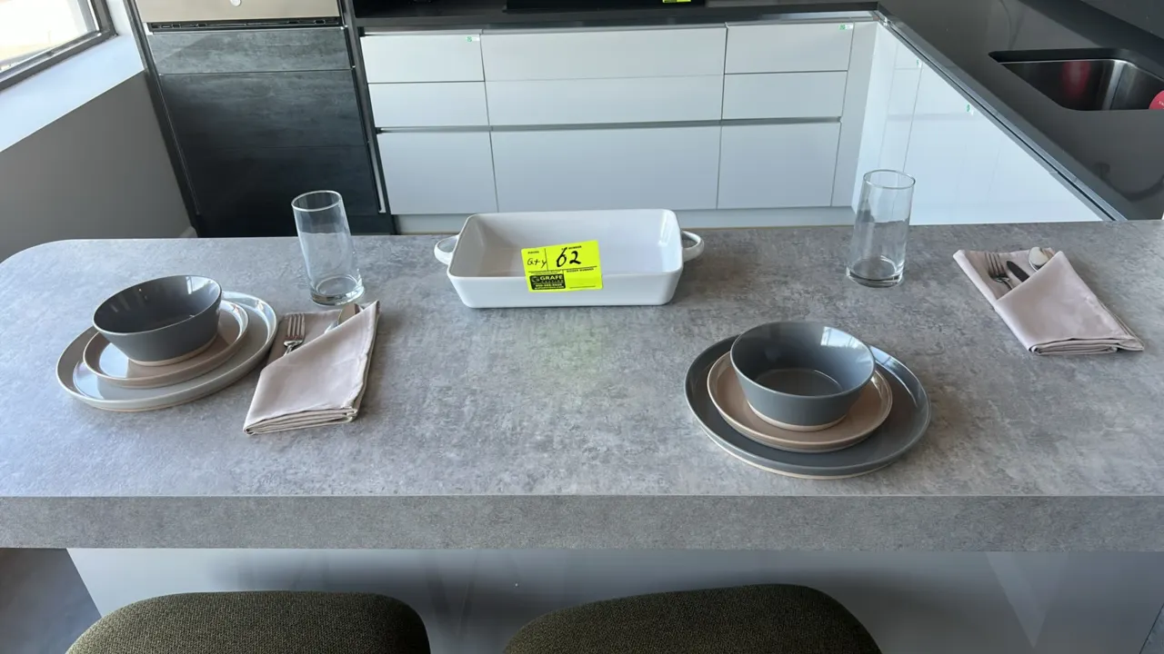 Assorted kitchenware and dinnerware smallwares. Includes ceramic dinner plates, salad plates, and bowls, a rectangular ceramic baking dish, assorted h
