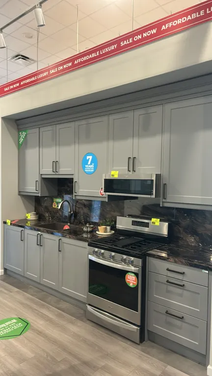 Infinity Plus laminate kitchen cabinets with laminate countertop. Features shaker-style upper and lower cabinets in a gray finish, single-basin sink,