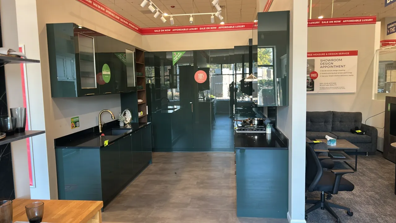 Wren Kitchens Infinity Plus laminate kitchen cabinets. Features green gloss finish, solid surface countertops, undermount single-basin sink with goose
