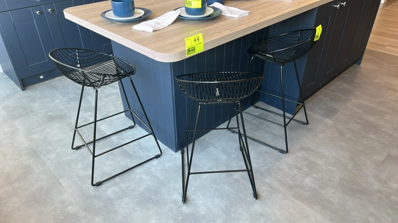 Metal wire barstools. Features black-finished wire scoop seats, integrated footrests, and sled-style bases with protective floor glides. Island and ba