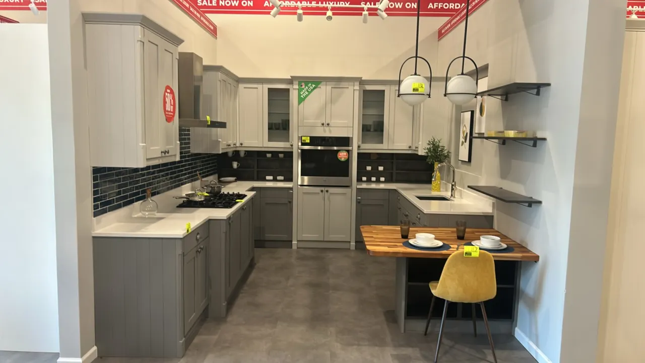 Infinity Plus laminate kitchen cabinets. Features two-tone shaker-style upper and lower cabinetry, fluted glass accents, white solid surface counterto