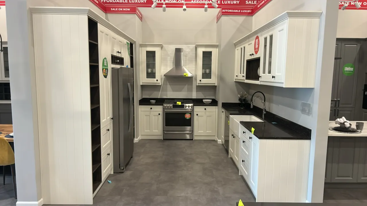 Infinity Plus laminate kitchen cabinet set. Features shaker-style white cabinetry, glass-front upper doors, built-in plate rack, wine storage, solid s