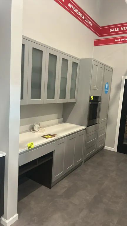 Infinity Plus laminate kitchen cabinet set. Features shaker-style cabinet doors, frosted glass upper cabinets, solid surface countertop, stainless ste