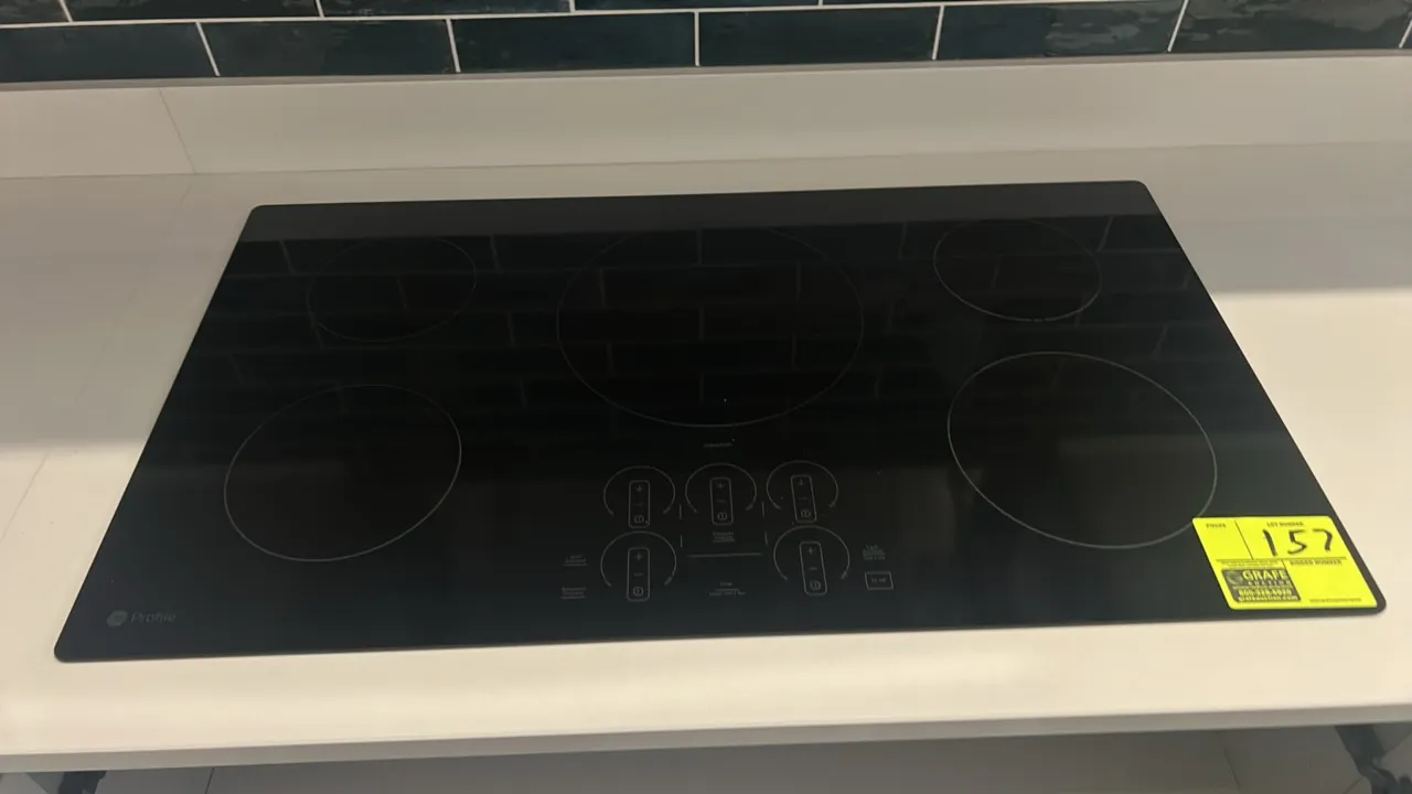 GE Profile PHP7036DT1BB built-in induction cooktop. Features 5 induction heating elements, digital touch controls, and black ceramic glass surface. 36