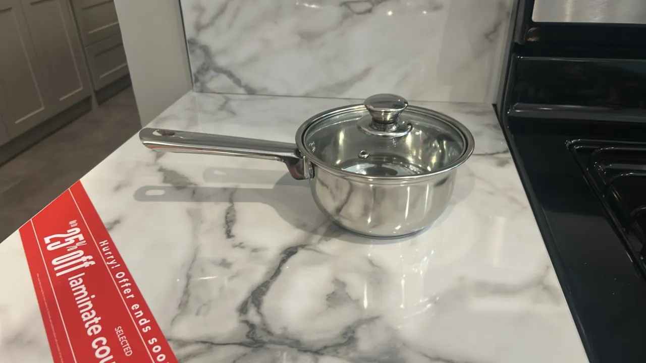 Assorted kitchenware and smallwares. Includes ceramic dinner plates, bowls, tumblers, and coffee mugs, a stainless steel saucepan with glass lid, and