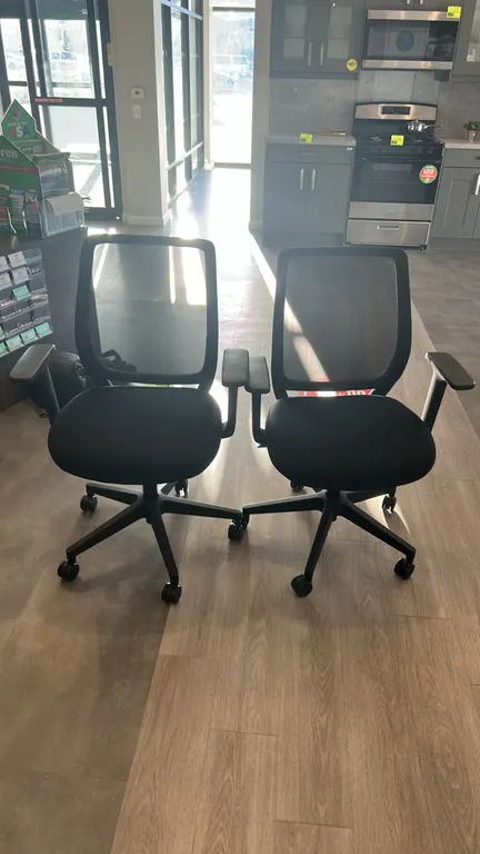 Office chairs. Features black mesh backrest, cushioned fabric seat, and armrests. Mounted on a 5-star base with dual-wheel casters.