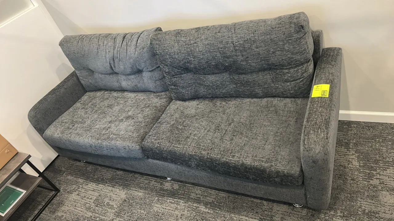 Cushioned lounge sofa. Features gray textured fabric upholstery, two-cushion seat design, tufted back cushions, and low-profile chrome feet. 7'L.