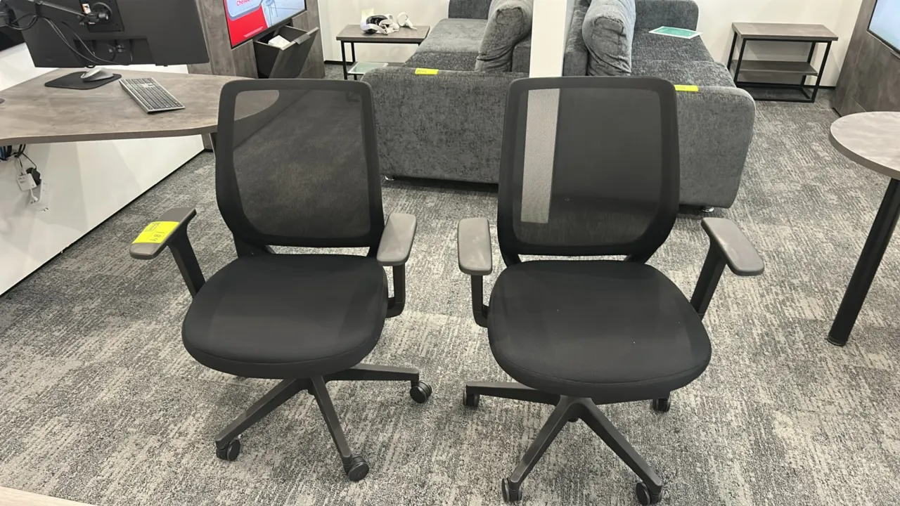 Mesh-back office chairs. Features black mesh backs, cushioned fabric seats, and armrests. Mounted on 5-star swivel bases with rolling casters.