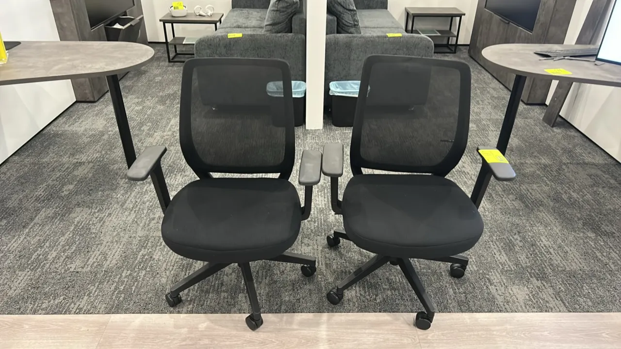 Mesh-back office chairs. Features breathable black mesh backrests, cushioned black fabric upholstered seats, and armrests. Mounted on 5-star swivel ca