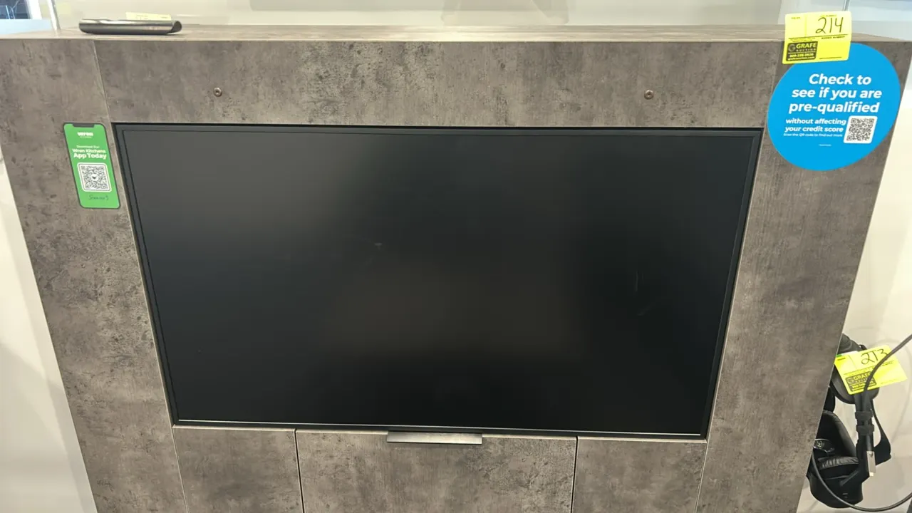49" flatscreen built-in display monitor. Housed in a gray faux-stone laminate partition cabinet. Includes remote control. Note: VR headset and backgro
