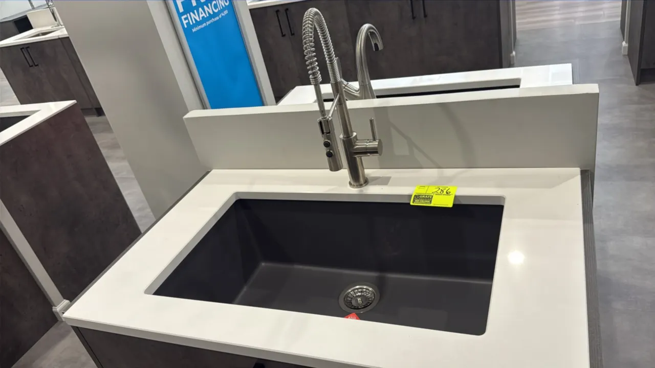 Single-bowl composite sink with pull-down faucet. Features a concrete gray finish, dual-mount design, stainless steel basket strainer, and single-hand