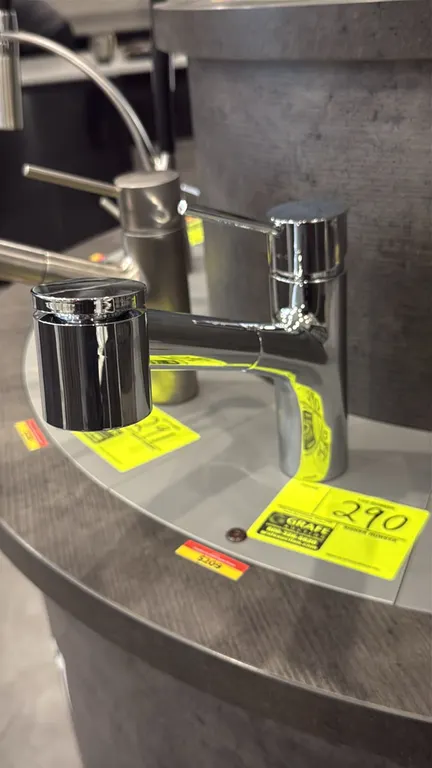 Canadian pull-down faucet. Features a polished chrome finish, single-lever handle, and pull-down spray head. Note: Display stand not included.