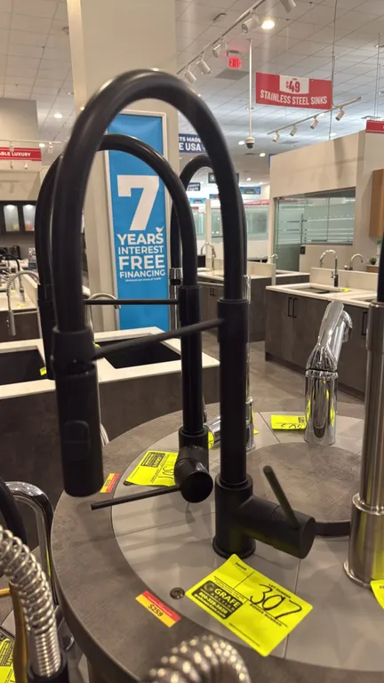 Kura pull-down kitchen faucet. Features a matte black finish, high-arc gooseneck spout, pull-down spray head with toggle control, and single-lever han