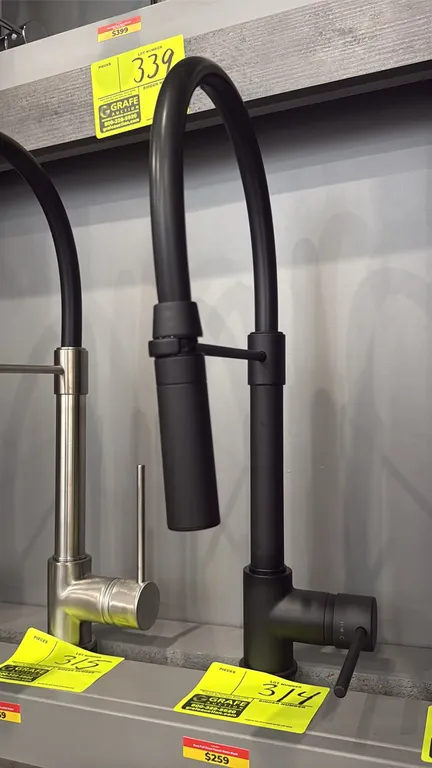 Kura pull-down kitchen faucet. Features a matte black finish, single-lever handle, high-arc spout, and pull-down spray head with horizontal docking ar