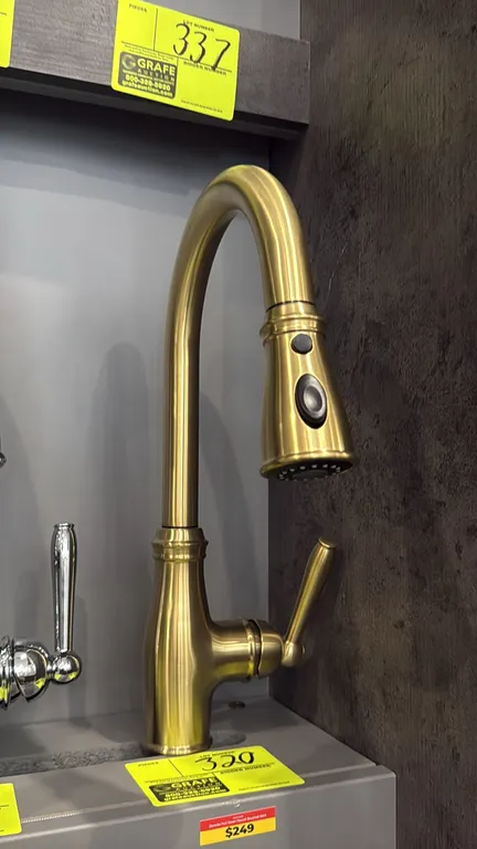 Danube FA.SAN.01.008 pull-down kitchen faucet. Features a brushed gold finish, high-arc swivel spout, pull-down spray wand with toggle button, and sin