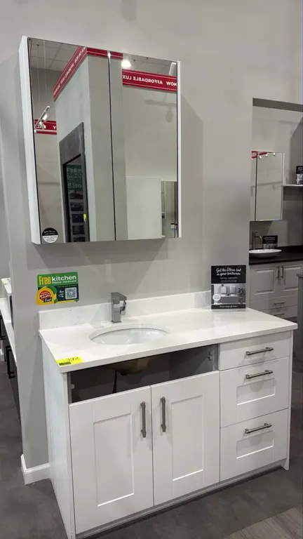 Wren Infinity bathroom vanity cabinet with matching 2-door mirrored medicine cabinet. Features white shaker-style finish, stone countertop with backsp