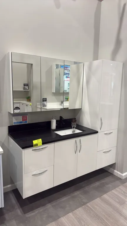 Infinity vanity cabinet ensemble. Features white high-gloss finish, black countertop, undermount sink, matte black single-handle faucet, 3-door mirror