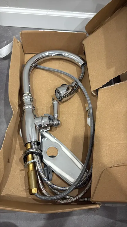 Pull-down kitchen faucet. Features a chrome finish, high-arc gooseneck spout, single-lever handle, and pull-down spray head with braided hose. Include