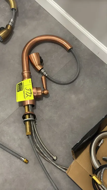 Pull-down kitchen faucet. Features a brushed copper finish, high-arc gooseneck spout, single-lever handle, pull-down spray head, and flexible braided