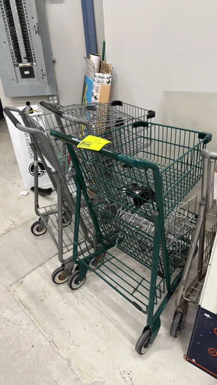 Assorted shopping carts. Features metal wire basket construction, lower rack storage, and push handles in assorted green and metal finishes. Mounted o