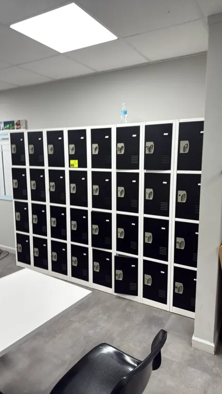 ADIRoffice 4-tier employee storage lockers. Features steel construction with white frames and black doors, louvered vents, recessed handles with keyed