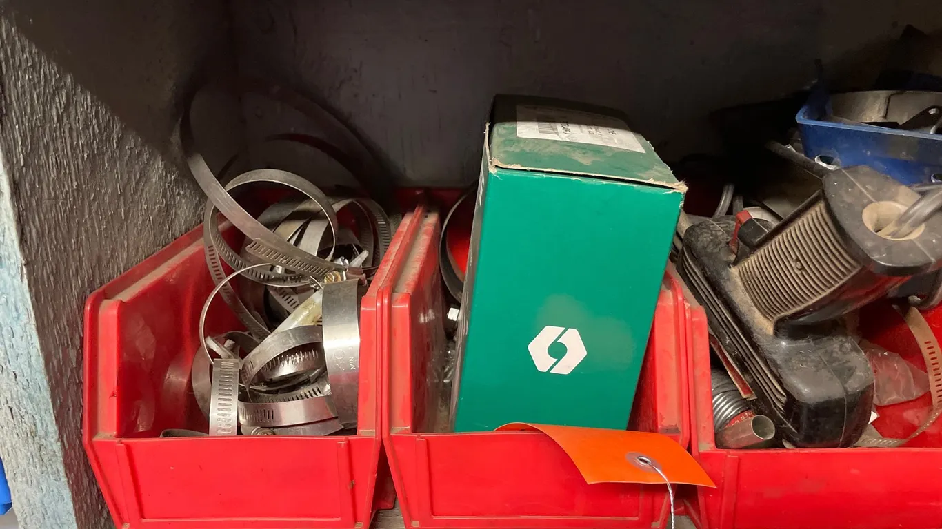 Red Plastic Storage Bins with Hardware, Corded Power Tool, Metal Sifter, and More