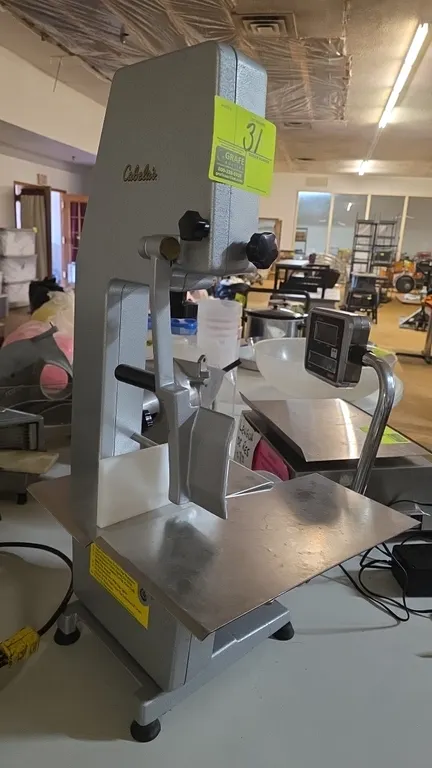 2006 Cabela's countertop meat saw. Features stainless steel table, integrated meat pusher guide, and a 1 HP induction motor (1720 RPM). S/N: OJ0300. E