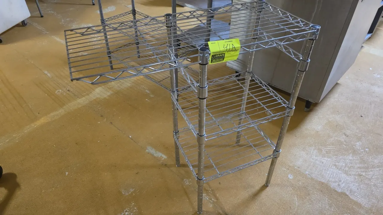 Chrome 3-tier wire shelving unit. Features wire construction with an extended 32.5" top shelf. 18" x 14" x 36.5". Mounted on leveling feet. Background