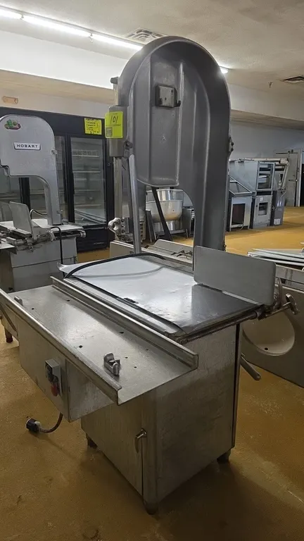 Biro 3334 commercial meat saw. Features stainless steel table assembly, thickness gauge plate, and push-button start/stop controls. Includes saw blade