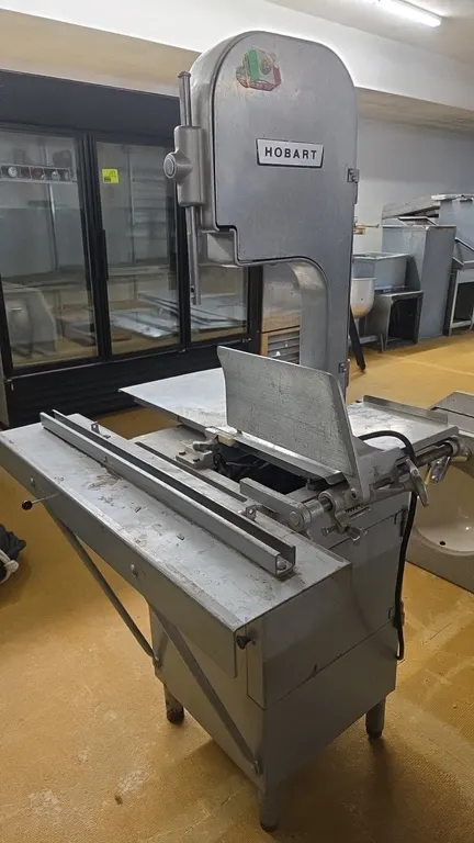 Hobart 5212 meat saw. Features stainless steel stationary table, thickness gauge plate, and blade guard. S/N: 11-126-084. Electrical: 230V, 60 Hz, 1-P