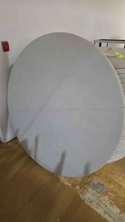 Round poly folding tables. Features a white molded polyethylene bi-fold top and folding metal leg frame. 60"Dia. Note: Visible crack on table edge.