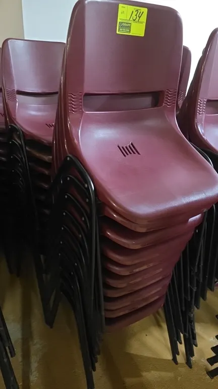 Polypropylene stacking chairs. Features molded maroon plastic seats and backrests with vented accents and integrated handle cutouts. Mounted on black