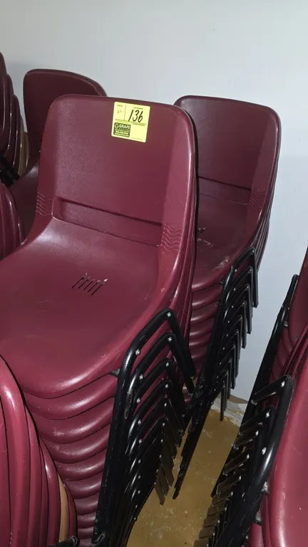 Poly stackable chairs. Features molded burgundy polypropylene shells with vented seats and integrated handle cutouts. Mounted on black tubular metal s