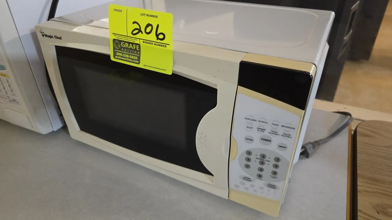 2010 Magic Chef MCM770W countertop microwave oven. Features digital keypad controls with cooking presets, express cook settings, and interior glass tu