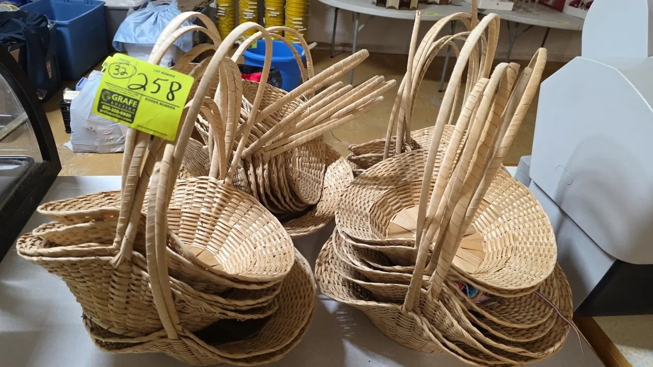 Lot of (32) woven baskets. Features natural woven construction with tall curved arch carrying handles.