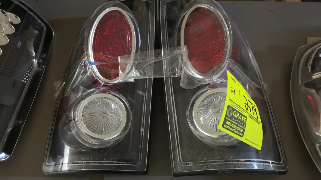 Ford tail light assembly set. Features clear outer lenses, black housings with chrome trim accents, and integrated red and clear lens sections. Stampe