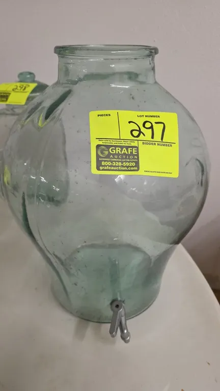 Vintage SVE 5-gallon green glass beverage dispenser urn. Features embossed volume markings, molded side handles, and a metal dispensing spigot. Made i