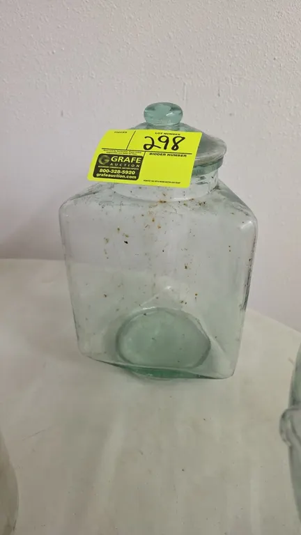 Vintage hexagonal tinted green glass storage jar. Features green-tinted glass construction and matching fitted glass lid with knob.