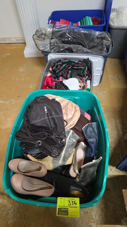 Storage totes with assorted contents. Features suits in protective garment bags, assorted footwear, boots, handbags, purses, fiesta-themed apparel, an