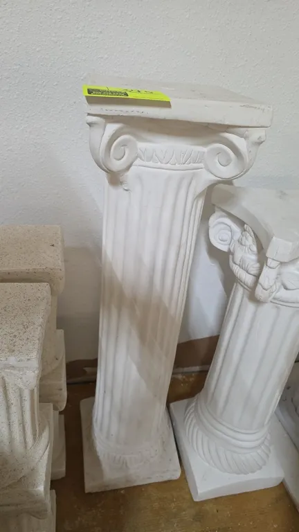 Lightweight plaster pedestal column. Features white finish, fluted shaft, Ionic-style capital, and square top with center opening. 35"H. Other columns