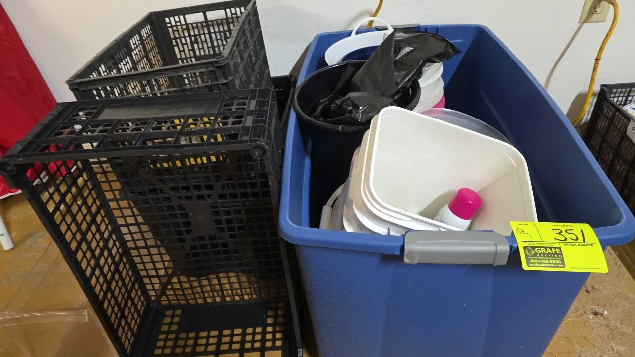 Assorted plastic storage totes and crates. Includes blue plastic latching tote and black plastic crates. Contents not included.