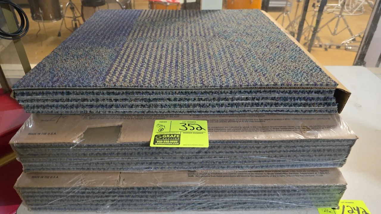 Shaw commercial modular carpet tiles. Features patterned loop pile in blue, gray, and tan tones. 24" x 24". Includes three packages (two shrink-wrappe