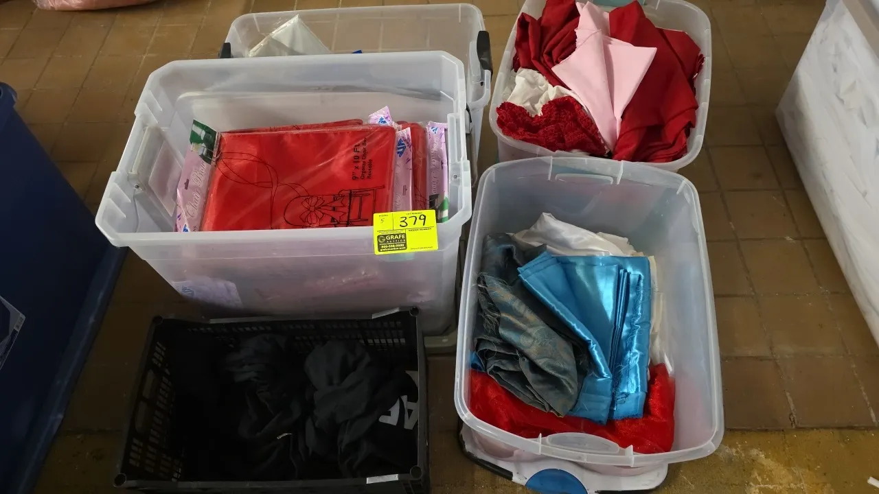 Assorted event linens and fabric lot. Includes (4) clear plastic storage totes and (1) plastic crate. Features packaged 9" x 10' organza chair bows, t