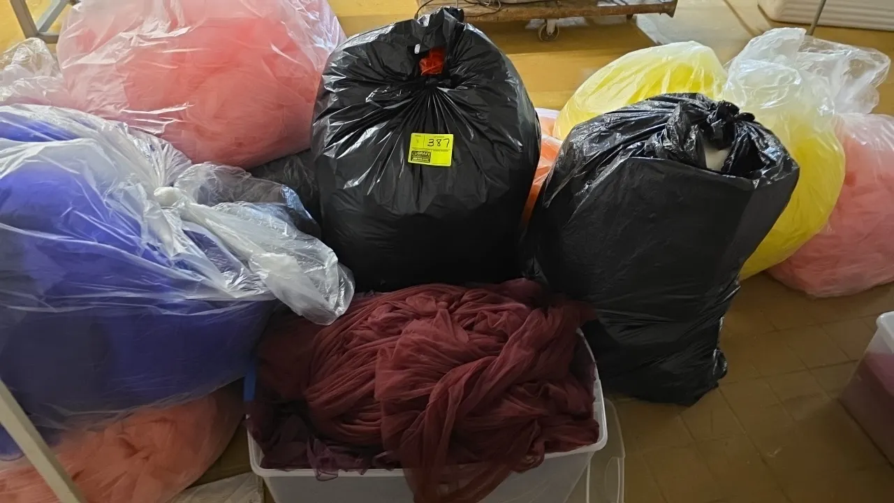 Assorted bow material and metal stands. Includes (11) poly tote and bags containing assorted color bow material, along with metal display stands.